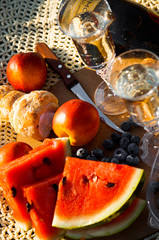 vacation picnic two glasses of champagne, blueberries, watermelon and croissants