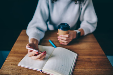 Lady with manicure working at table while holding beverage