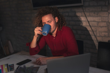 Man drinking coffee and working in an office