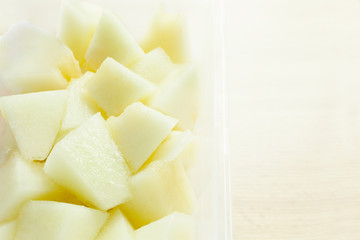 Small pieces of freshly cut melon in white bowl
