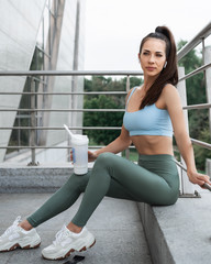 Obraz premium Fitness woman in sportswear rests after an outdoor fitness workout