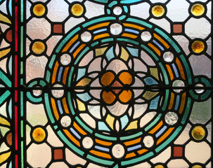 multicolored stained glass window with a flower pattern in a circle