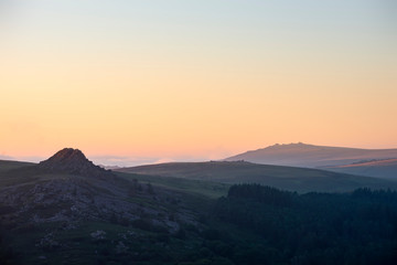 Absolutely stunning landscape image of Dartmoor in England showing Leather Tor and Kings Tor in majestic sunrise light
