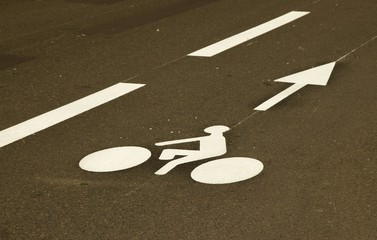 White bike sign and forward arrow on the road. Safe cycling on the road. Bicycle path for moving forward.