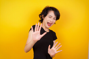 Dissatisfied female model frowns face, has disgusting expression, shows tongue, expresses non...
