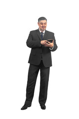 A man businessman in a suit stands with a tablet in his hands