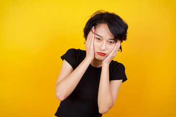 Portrait of beautiful young woman holding head in hands with unhappy expression watching sad movie about animals and trying not to cry.