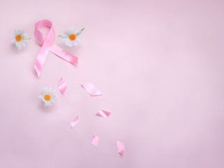 Breast cancer awareness pink ribbon with daisy flower on pink background, october symbol, healthcare and medicine concept