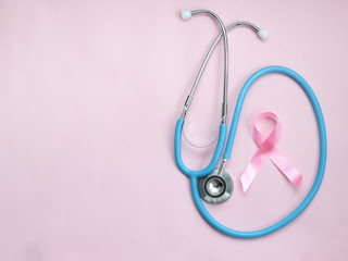 Fototapeta premium Breast cancer awareness pink ribbon with doctor stethoscope on pink background, october symbol, healthcare and medicine concept ....