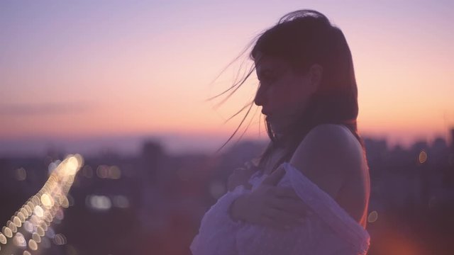 Pensive lonely girl standing outdoors, night city background, breakup problem