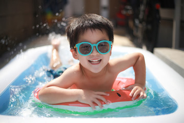 ビニールプールで遊ぶ男の子