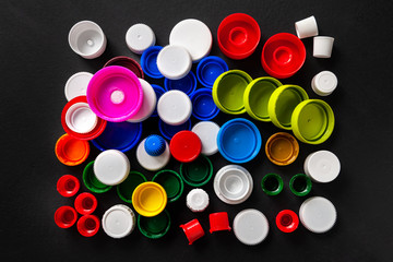 Composition of plastic bottle caps. Top view of recycled plastic bottle caps. Separate garbage collection. Recycling of plastic for prosthetics. Selective focus.