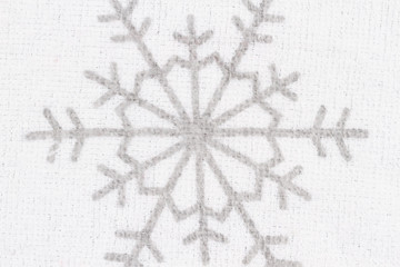 Snowflake on white textured fabric closeup background