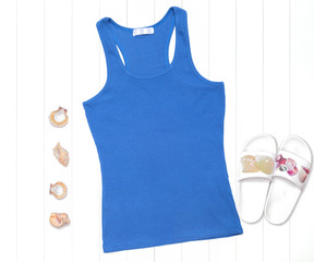 Neon blue tank top with seashells and flip flops on white background