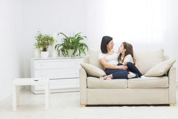 Obraz premium Photo of a beautiful mother and her little girl sitting at home and sharing a happy moment together.