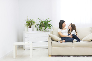 Obraz premium Photo of a beautiful mother and her little girl sitting at home and sharing a happy moment together.