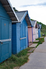 A row of traditional wooden beach huts lined along the promenade in the seaside town fo Cromer on the North Norfolk coast