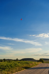 Red heart shaped balloon on landscape background