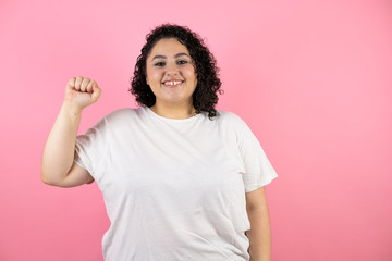 Young beautiful woman isolated pink background smiling and fist raised.