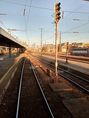 A train traveling down train tracks near a station