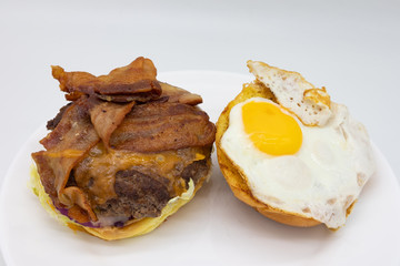Open Bacon Cheese Burger with a Sunny Side Up Egg on a White Plate with a White Background