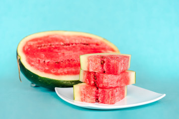Water melon slices on a plate on blue background