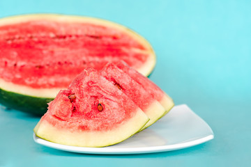 Water melon slices on a plate on blue background