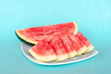 Water melon slices on a plate on blue background