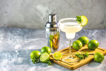 Margarita cocktail with lime and ice on minton light gray concrete table with amazing backlight, copy space. Classic Margarita or Daiquiry Cocktail.