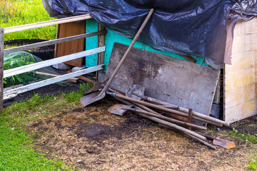 Primitive mechanical agricultural hand tools at fence on farm