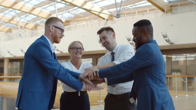 International business team showing unity with their hands stacked together in pile.