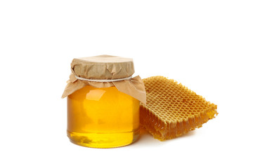 Glass jar of honey and honeycomb isolated on white background
