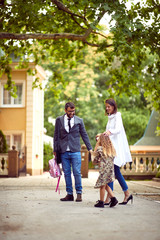Obraz premium Mom and dad walking with daughter