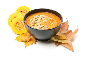 Leaves, slices of squash and bowl of pumpkin soup isolated on white background