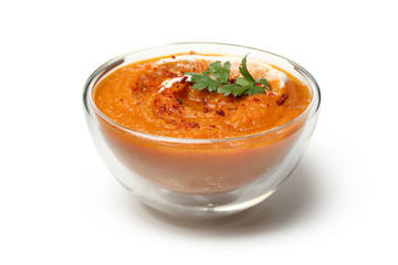 Bowl of pumpkin puree with parsley isolated on white background
