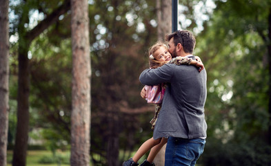 Father embracing daughter after school