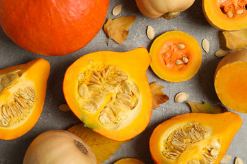 Composition with pumpkin, squash, seeds and leaves on gray background