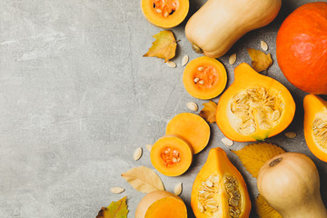 Composition with pumpkin, squash, seeds and leaves on gray background
