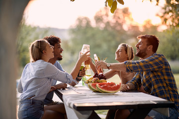 Friends  toasting and drinks  outdoor at sunset. - Powered by Adobe