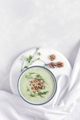 Avocado and spinach cream soup with nuts and microgreens. Top view. Diet food concept. Vegetarian and vegan food.