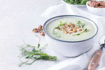 Avocado and spinach cream soup with nuts and microgreens. Diet food concept. Vegetarian food. Healthy eating