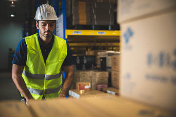 Male warehouse worker working for check and analyze newly arrived goods for further placement in...