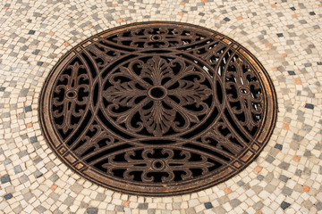 Ancient manhole on a mosaic floor

