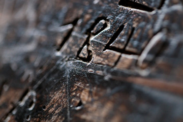 Horizontal detail view of a roughly carved inscription «1840» on a wooden surface. Hand carved date on wood furniture.