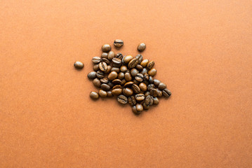 Coffee beans on brown background close up