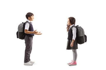 Full length profile shot of a schoolboy gesturing with hands and talking to a schoolgirl