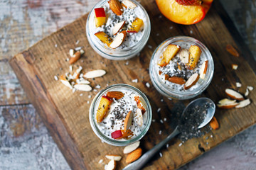 Selective focus. Macro. Jars of chia yogurt. Healthy yoghurts in jars with chia, almonds and peaches. Breakfast trend.