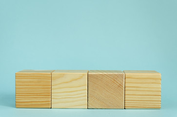 Construction of wooden cubes on blue background with copy space. Mockup composition for design