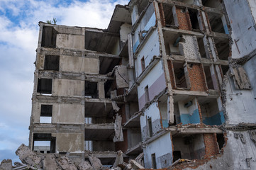 Destroyed house close-up against a blue sky with gray clouds. Background