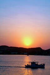 Greece, Patmos island, sun rising, sun's first appearance in the morning above Patmos island.